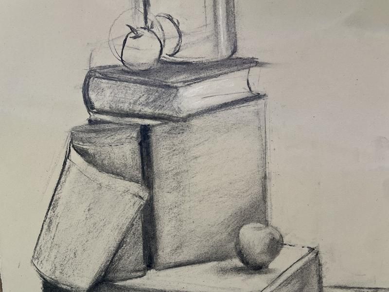 Tonal charcoal still-life study of stacked boxes, books and a jar