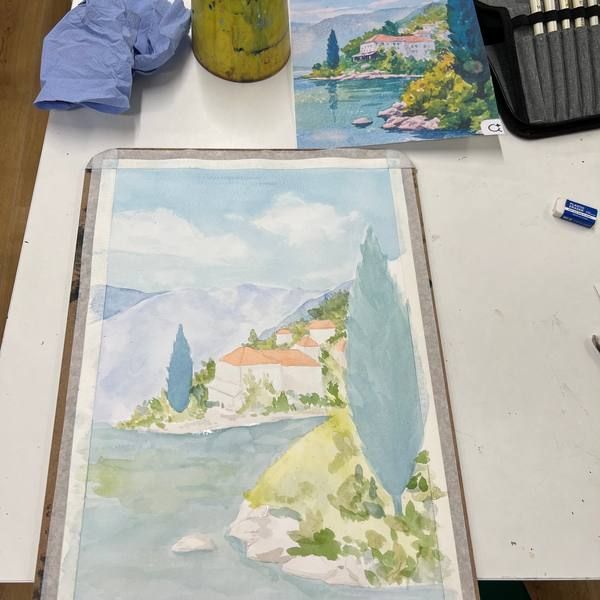 Watercolour of a hillside village by the water