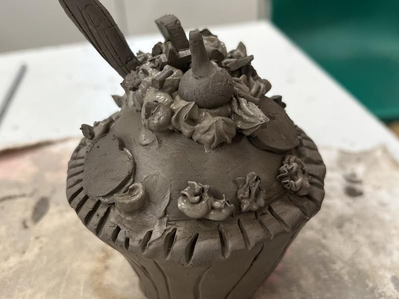 A clay cupcake pot decorated with sprinkles, made in a children's class