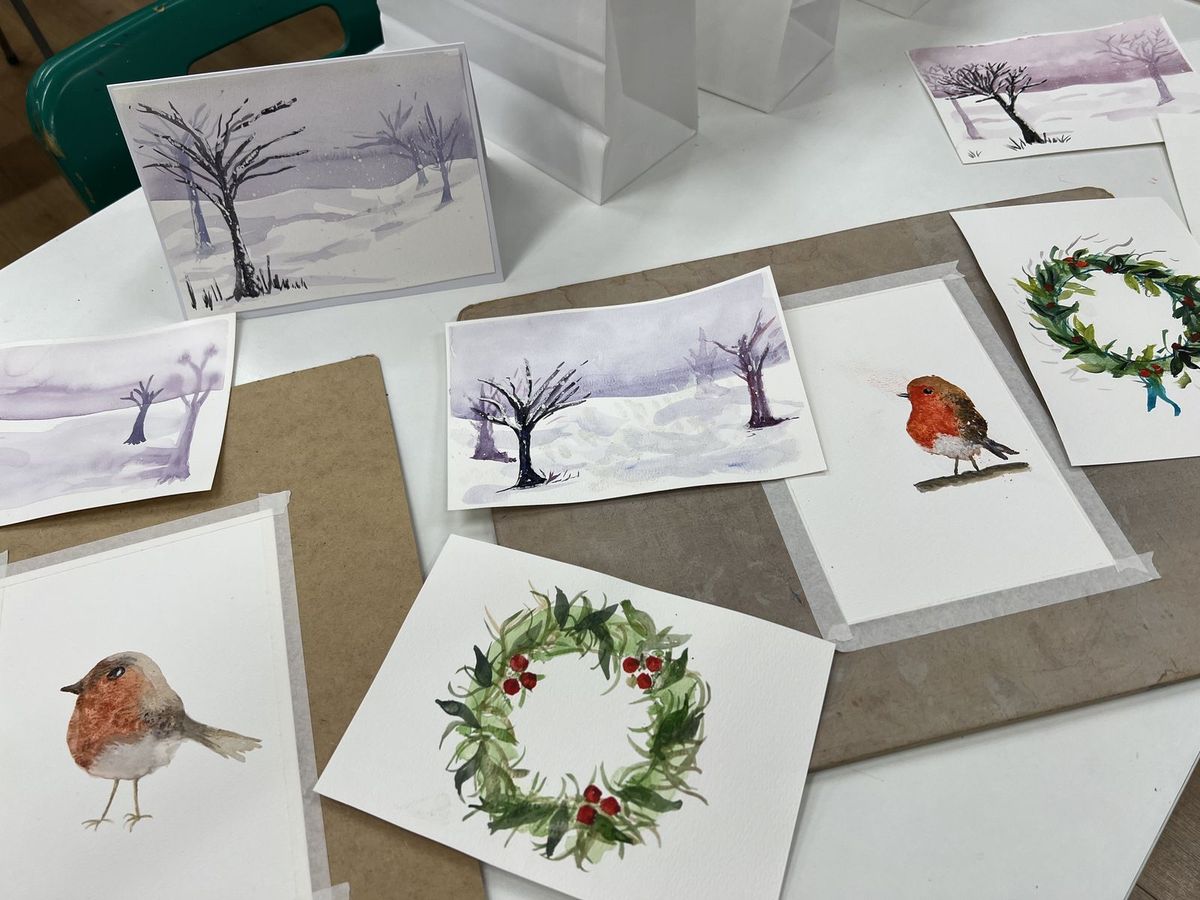 Finished watercolour Christmas cards with a robin, a wreath and snowy trees